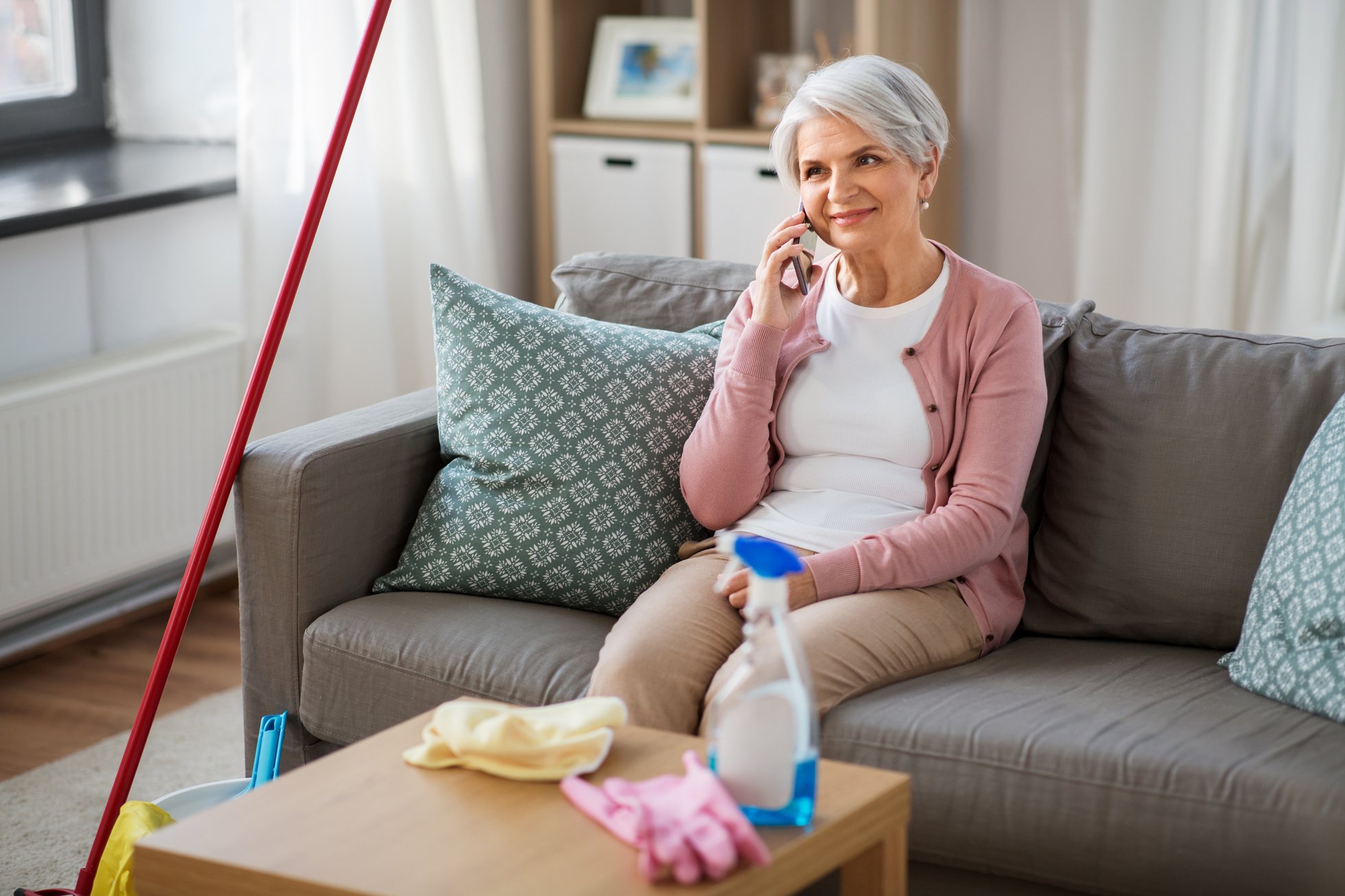 Old Woman Calling on Cellphone after Cleaning Home